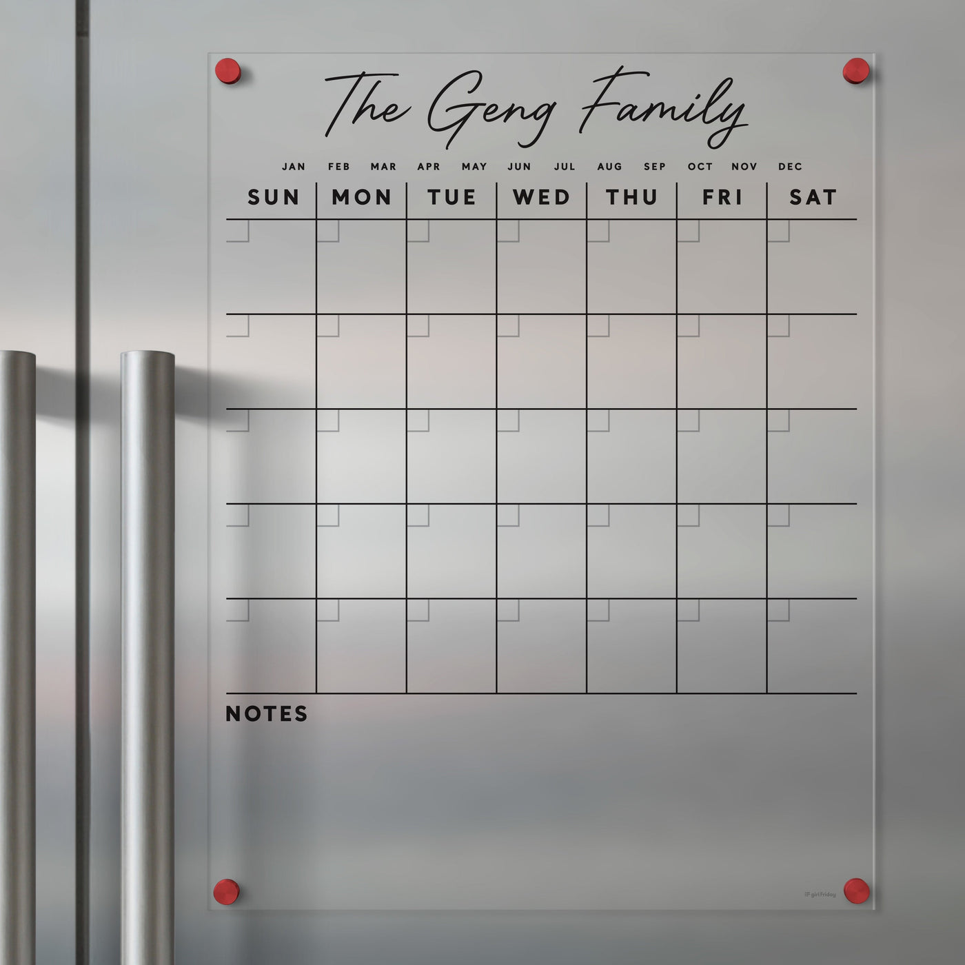 Girl Fridays Clear Acrylic Monthly Calendar for Fridge features a custom family name, like The Geng Family. It includes labeled days, columns, and note spaces. The calendar sticks to your fridge with red magnets and is ideal for wet-erase markers.