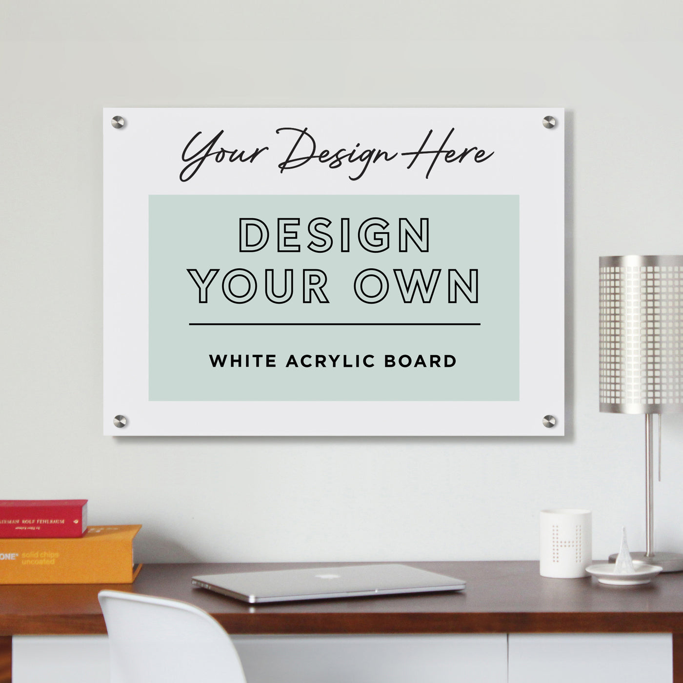 A workspace with a laptop on a wooden desk, alongside a white chair and small silver lamp. A wall poster reads, Girl Friday - Design Your Own Floating White Acrylic Board | Horizontal - Customize Your Premium Surface.