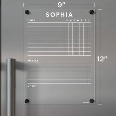 The Girl Friday acrylic fridge chore chart features clear, white text with Sophia at the top. It has daily columns for Sunday to Saturday, weekly tasks, and notes sections on a 9x12-inch surface. Use wet-erase markers and secure it with corner posts as a functional calendar for your fridge.