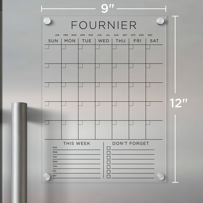 The Girl Friday Acrylic Fridge Calendar features custom family names, Sunday-Saturday grids, a This Week section for daily tasks, and a Dont Forget checklist. Its ideal for wet-erase markers, measures 9x12, and mounts with silver standoffs.