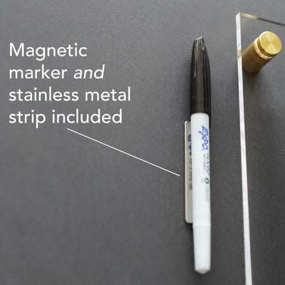 Fasten the black marker to the wall with a stainless metal strip featuring Magnetic marker and stainless metal strip included. A writing surface for wet-erase markers complements the brass-colored knob, perfectly paired with Girl Friday Shops Acrylic Calendar with side notes.