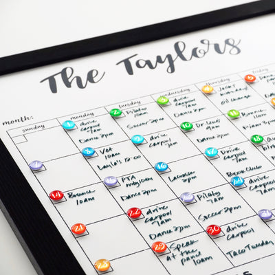 CalendarGirlCompanys 18 x 24 Framed Whiteboard Calendar, #18420, features an acrylic surface and colorful magnets for marking activities. Chalk ink markers set dates and events in a black frame for an organized touch.