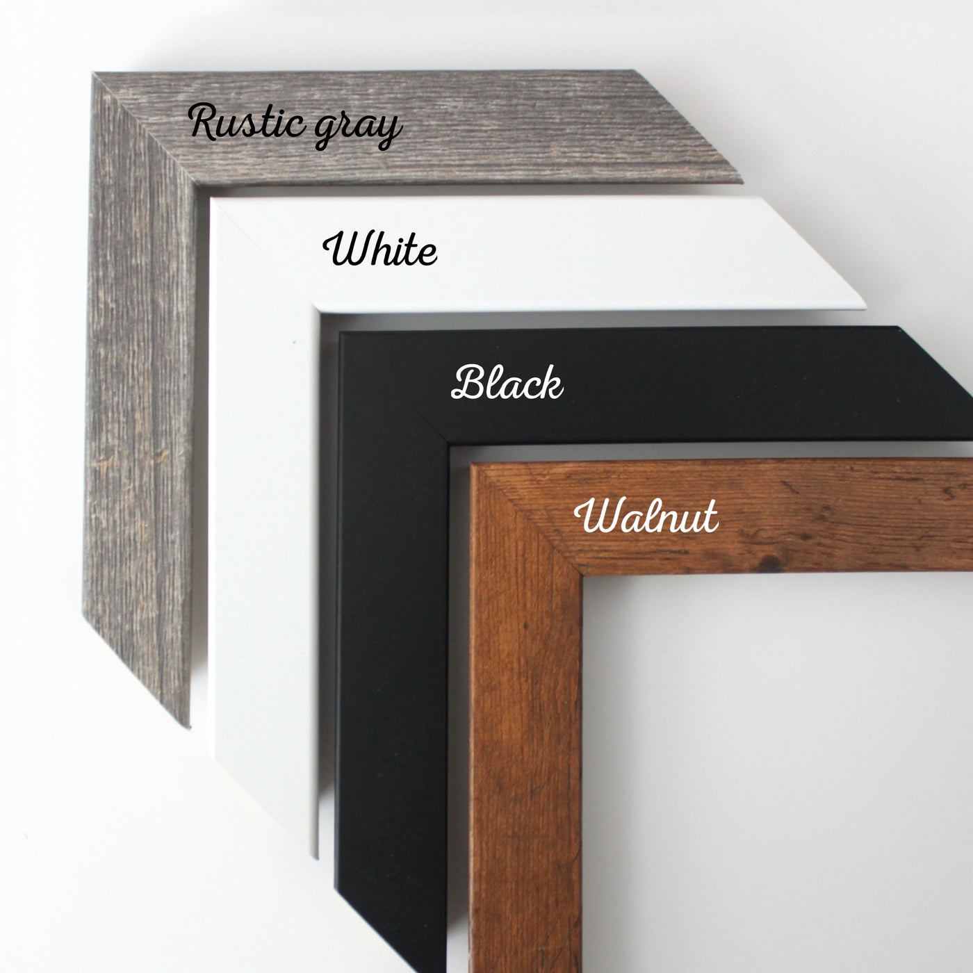 Four picture frame corners overlap, ideal for a framed calendar display. From top to bottom, they are labeled: Rustic gray wood texture, White, Black, and Walnut with rich brown wood grain. Perfect for your 9 X 24 Framed Weekly Chalkboard Calendar by CalendarGirlCompany (#920).