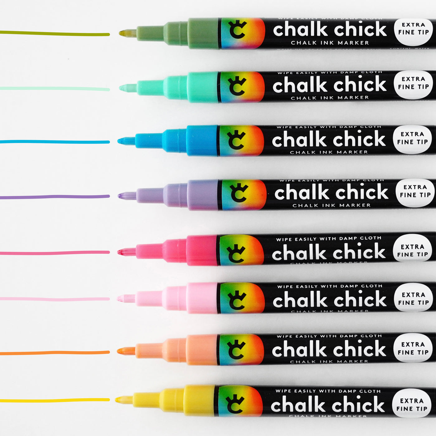 Ten vibrant Floral Chalk Ink Markers by Girl Friday Shop, perfect for acrylic boards, line up horizontally, each leaving a matching line above. With extra fine tips and black bodies labeled Wipe Easily with Damp Cloth, colors range from yellow to pink and purple.