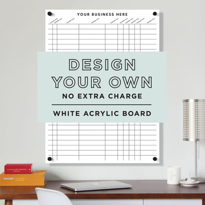 A Girl Friday vertical wall-mounted white acrylic board with a customizable design option is displayed, showcasing its dry-erase surface. A text overlay reads: Design Your Own, with no extra charge. Nearby, a lamp adorns the desk.