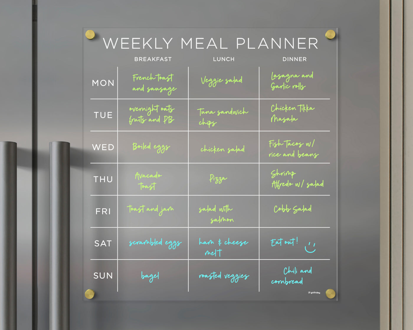 The Girl Friday Shops Clear Acrylic Fridge Meal Planner is a magnetic tool for weekly meal organization. With neon text on a grey background, it includes options like bagels and salads. Update plans daily with wet-erase markers for breakfast, lunch, and dinner.