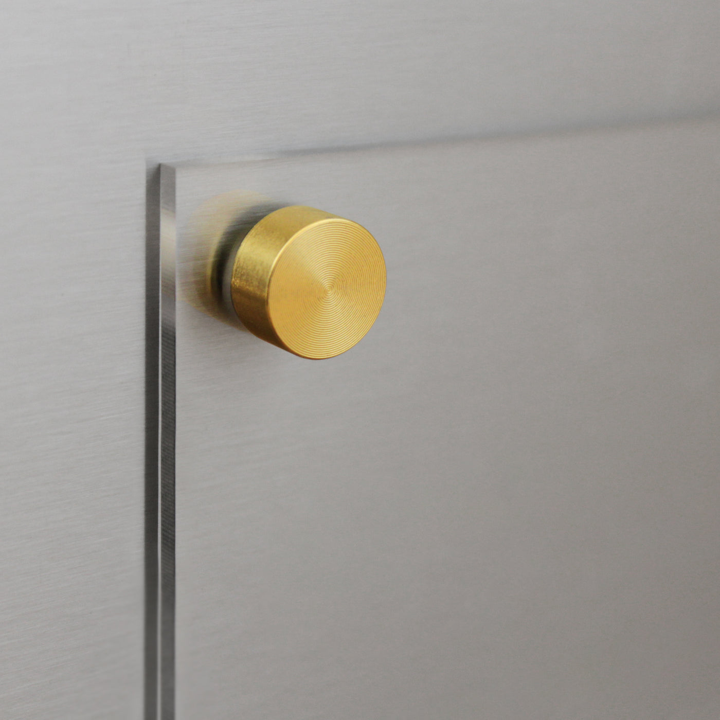 A close-up of the Clear Acrylic Fridge Meal Planner by Girl Friday Shop shows it mounted on a brushed metal surface with a round brass fastener. The brass contrasts with the sleek, transparent materials, creating a modern, minimalist look ideal for use with dry-erase markers.
