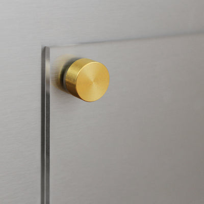 A close-up of the Clear Acrylic Fridge Meal Planner by Girl Friday Shop shows it mounted on a brushed metal surface with a round brass fastener. The brass contrasts with the sleek, transparent materials, creating a modern, minimalist look ideal for use with dry-erase markers.