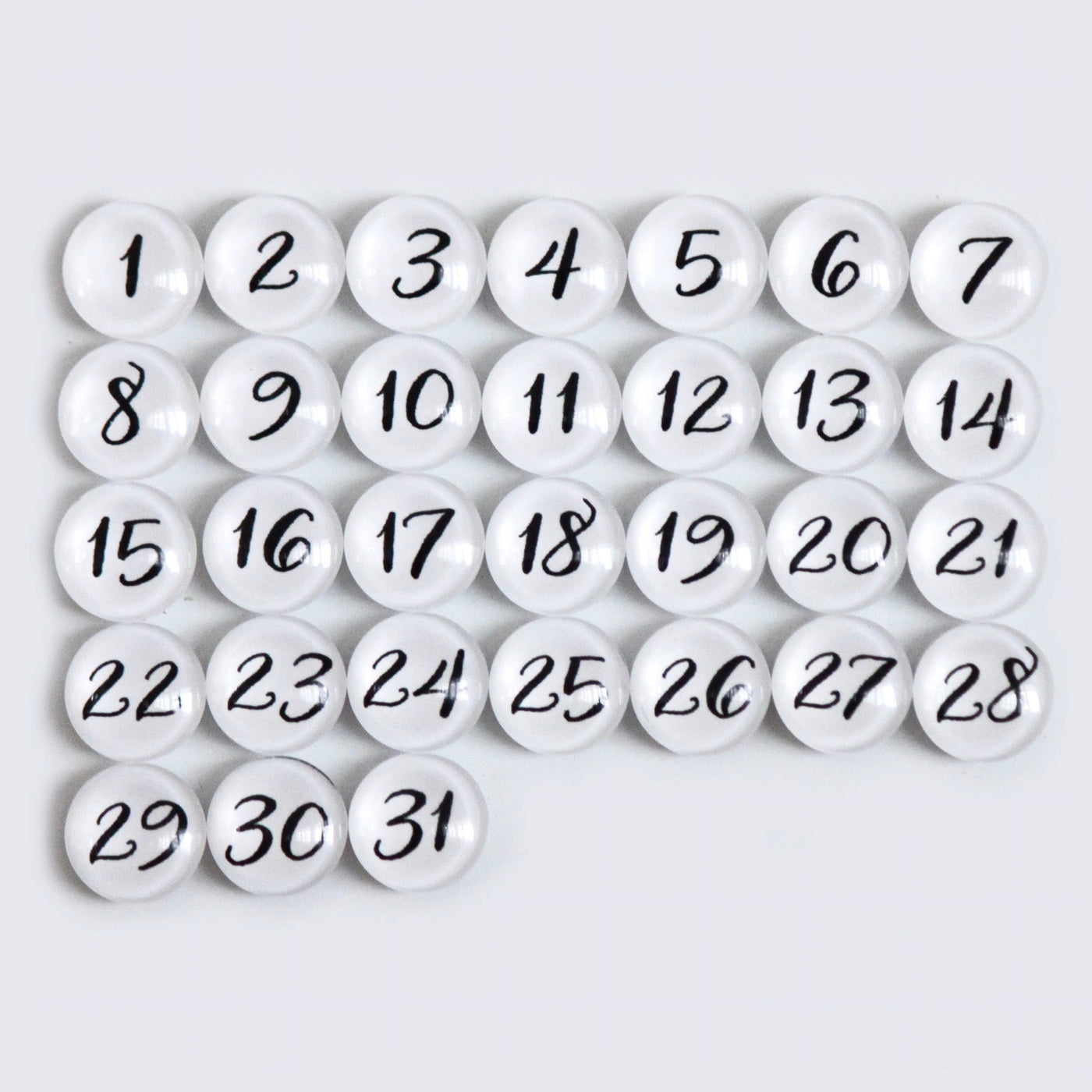 The CalendarGirlCompanys 24 X 18 Framed Whiteboard Calendar #18203 features a neat grid of 31 premium acrylic white circular magnets, each with black numbers from 1 to 31, set against a light gray background for an elegant display.