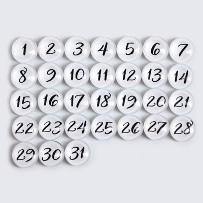 The CalendarGirlCompanys 24 X 18 Framed Whiteboard Calendar #18203 features a neat grid of 31 premium acrylic white circular magnets, each with black numbers from 1 to 31, set against a light gray background for an elegant display.