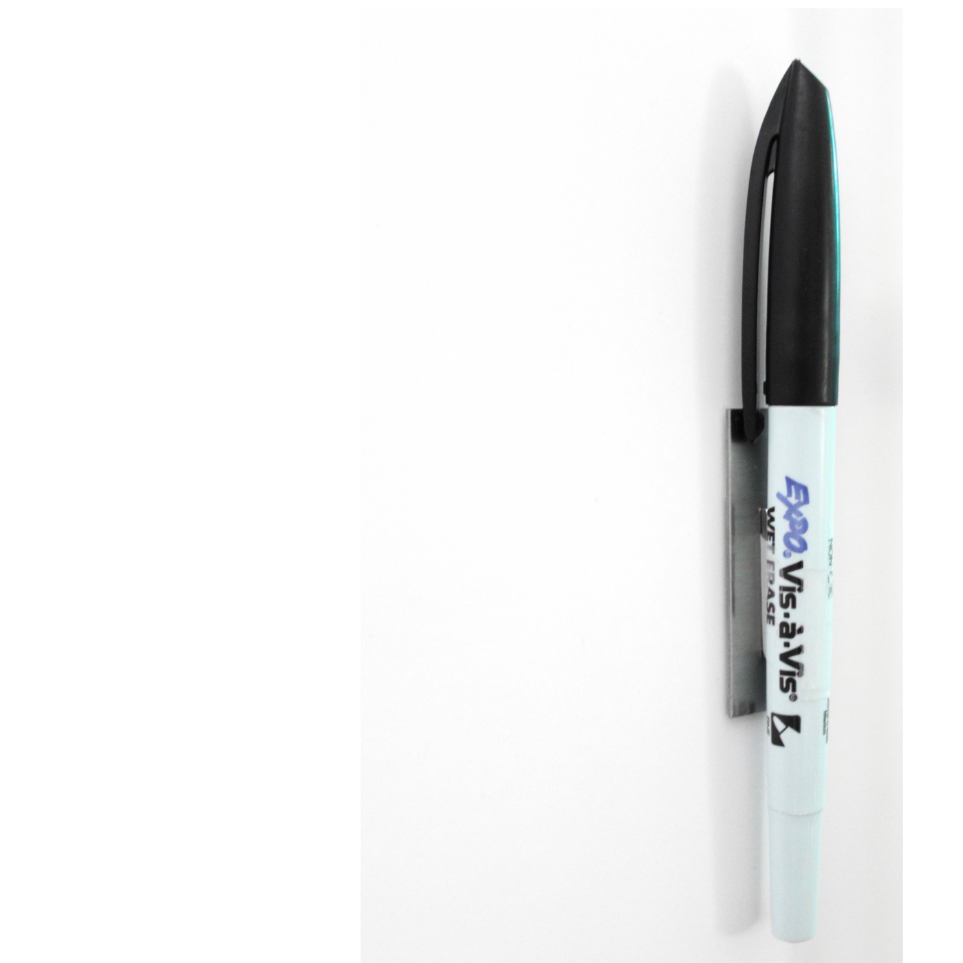 A Girl Friday Shop dry-erase marker with a blue barrel and black cap clips onto a white surface, ideal for use on the White Acrylic Dry Erase Board or any non-magnetic fridge.