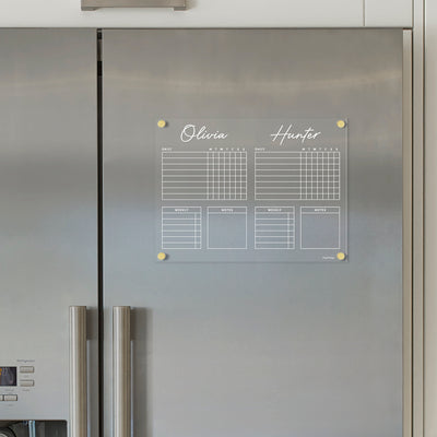 An Acrylic Fridge Chore Chart by Girl Friday, designed for two children, includes daily and weekly grids for Olivia and Hunter. Attached with four magnets, its perfect for wet-erase markers.