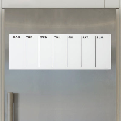 The White Acrylic Dry Erase Weekly Calendar by Girl Friday Shop offers a damage-free mounting solution on stainless steel refrigerators. Its magnetic design includes columns labeled MON through SUN, keeping your schedule organized and visible.