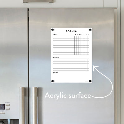 A silver fridge displays the Girl Friday Shops customizable acrylic dry erase board, personalized for Sophia. It includes Daily, Weekly, and Notes sections, with an arrow emphasizing its robust surface for organizing tasks using neodymium magnet-secured chore charts.