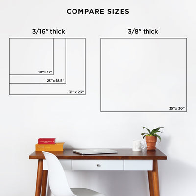 Comparison of two Girl Friday Shop whiteboards: one is 3/16 thick available in sizes 18x15, 23x18.5, and 31x23; the other is a sturdier option at 3/8 thick, size 35x30. Both elegantly rest on dark walls above a desk with a chair, small plant, and stacked books.