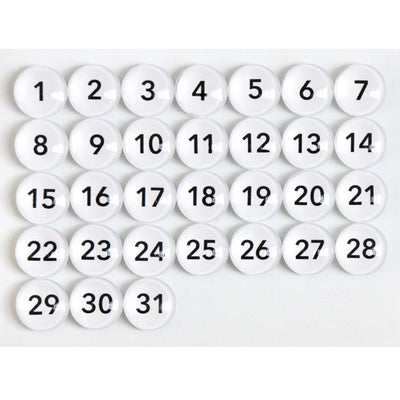 A grid of 31 round magnets, Number Magnets - White by Girl Friday, features sequential black numbers from 1 to 31. The white glass magnets are evenly arranged in four rows on a plain background.