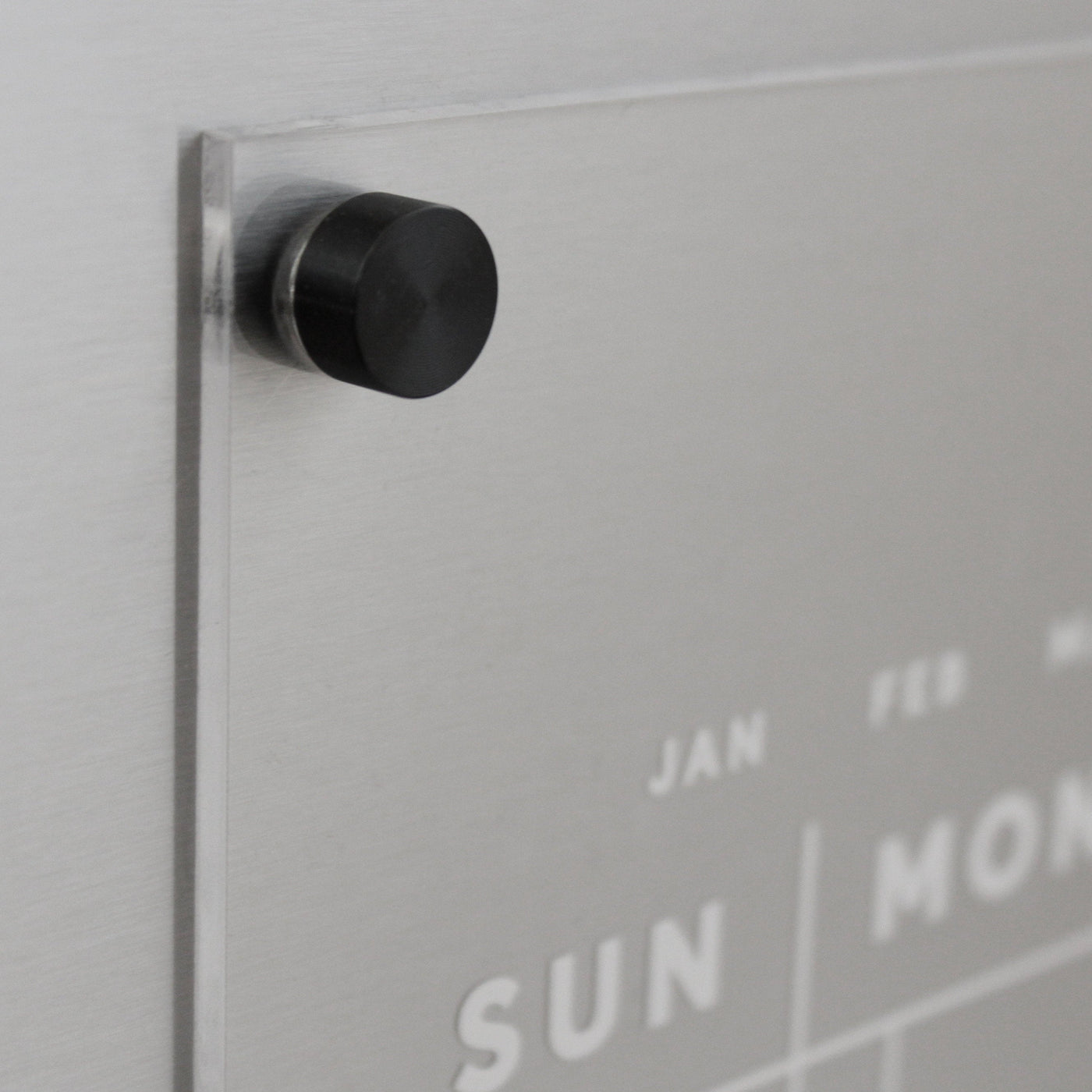 Acrylic Fridge Calendar | Custom Family Name by Girl Friday: Featuring a transparent acrylic surface with white days and months, this calendar is ideal for wet-erase markers. A sleek metal finish and round black magnet in the top left corner provide a modern touch.