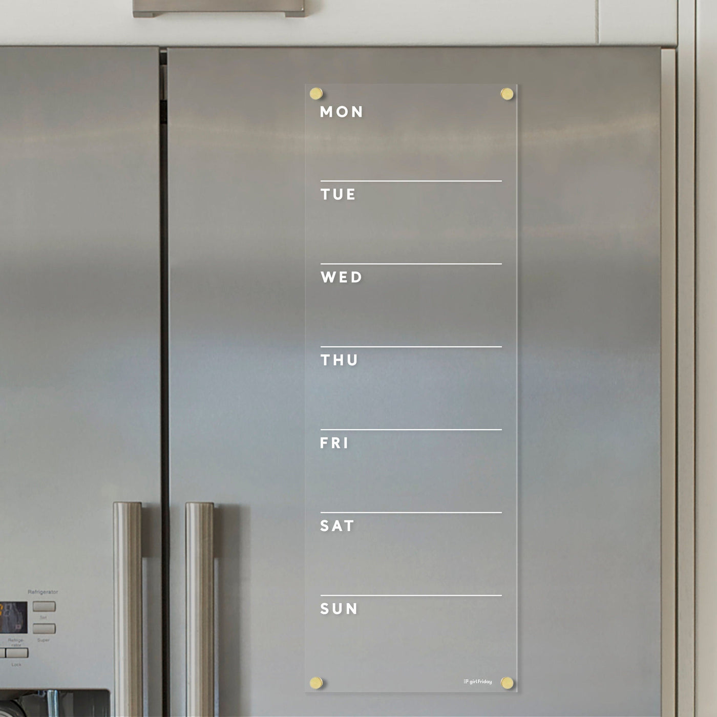 The Clear Acrylic Weekly Fridge Calendar by Girl Friday features white text and adheres to a stainless steel refrigerator, offering ample note space for each day. Perfect for wet-erase markers, its ideal for jotting down reminders in style.