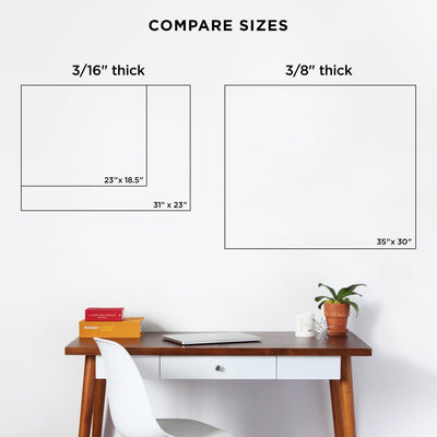 A hardwood desk with a white drawer and chair is complemented by two frames above—sizes 23 x 18.5, 31 x 23, and 35 x 30. A plant, books, and the Girl Friday Clear Acrylic Customizable Monthly & Weekly Wall Calendar for wet-erase markers add functional charm.