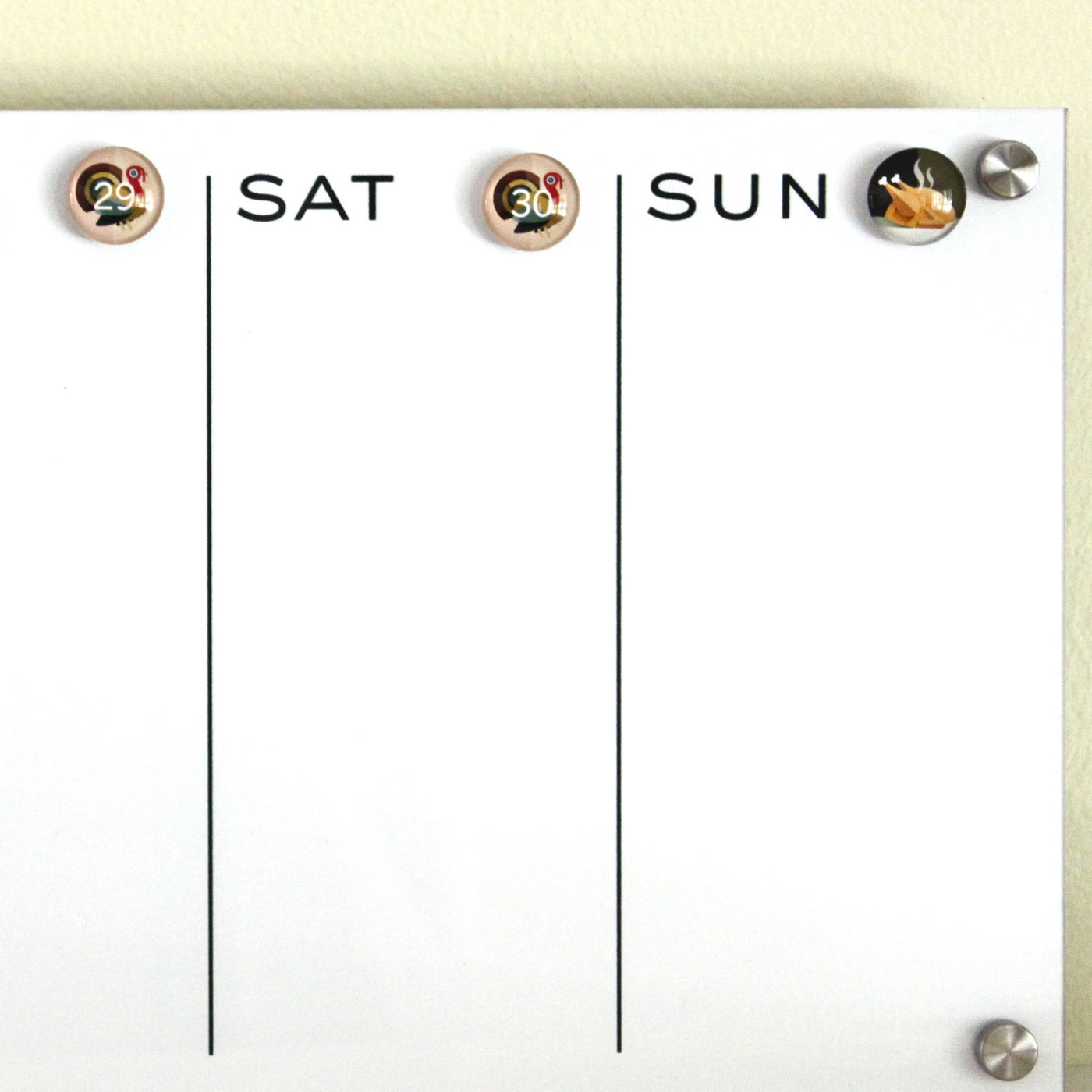 The Girl Friday whiteboard calendar emphasizes the weekend with a turkey icon on Saturday the 29th and a turkey leg on Sunday the 30th, separated by vertical lines. Ideal with Number Magnets - Thanksgiving! Turkey Day, it enhances your kitchens festive charm.